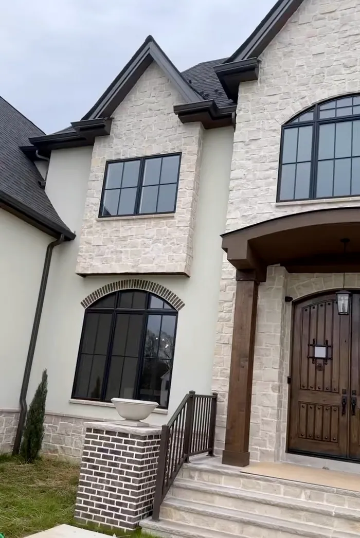 A newly built stone house with arched windows
